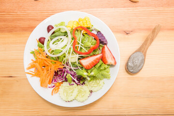 Fresh healthy salad on wooden table. View from above with copy space