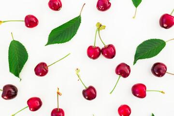 Food pattern of cherries and leaves on white background. Flat lay. Top view. Summer concept