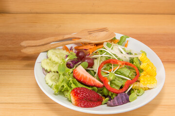Fresh healthy salad on wooden table. View from above with copy space