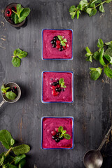 Top view Berry smoothie on black wooden background - Well being, Healthy eating, Detox or Diet concept. Selective focus, flat lay