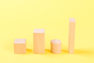 Wooden building blocks on yellow background.