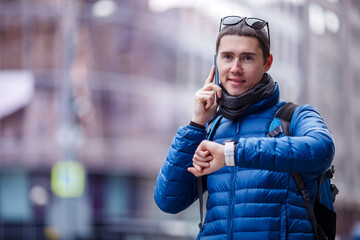 Man talking on phone and looking at smartwatch