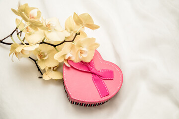 gift box in form of heart on the background of the yellow orchid