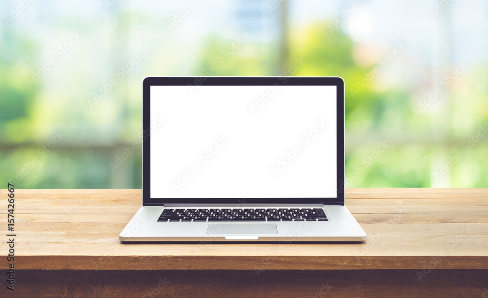Wall mural modern computer,laptop with blank screen on table with window view background