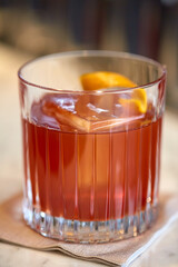 close up of glass with orange cocktail at bar