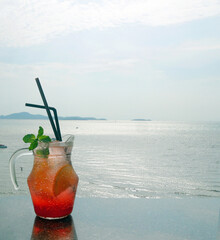 Jar of refreshing iced fruit punch over looking bright wide ocean
