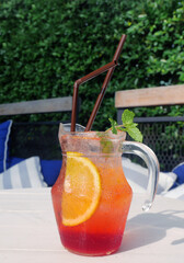 Jar of refreshing iced fruit punch on a beach table