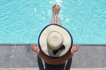 Beautiful woman sunbathing by the pool top view. Summer background.