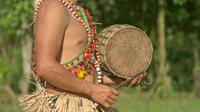 Indigena amaz&oacute;nico tocando el tambor 