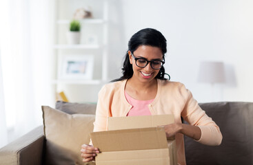 happy young indian woman with parcel box at home