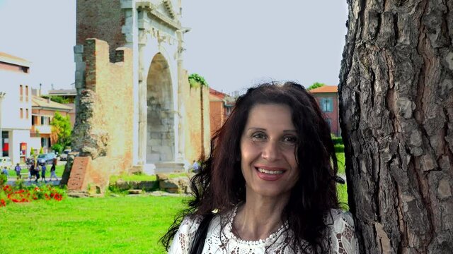 portrait of woman with Roman Arch in background in Rimini, Italy
