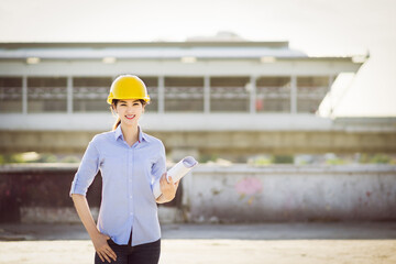 Portrait cute asian woman engineer standing and smiling at construction workplace.