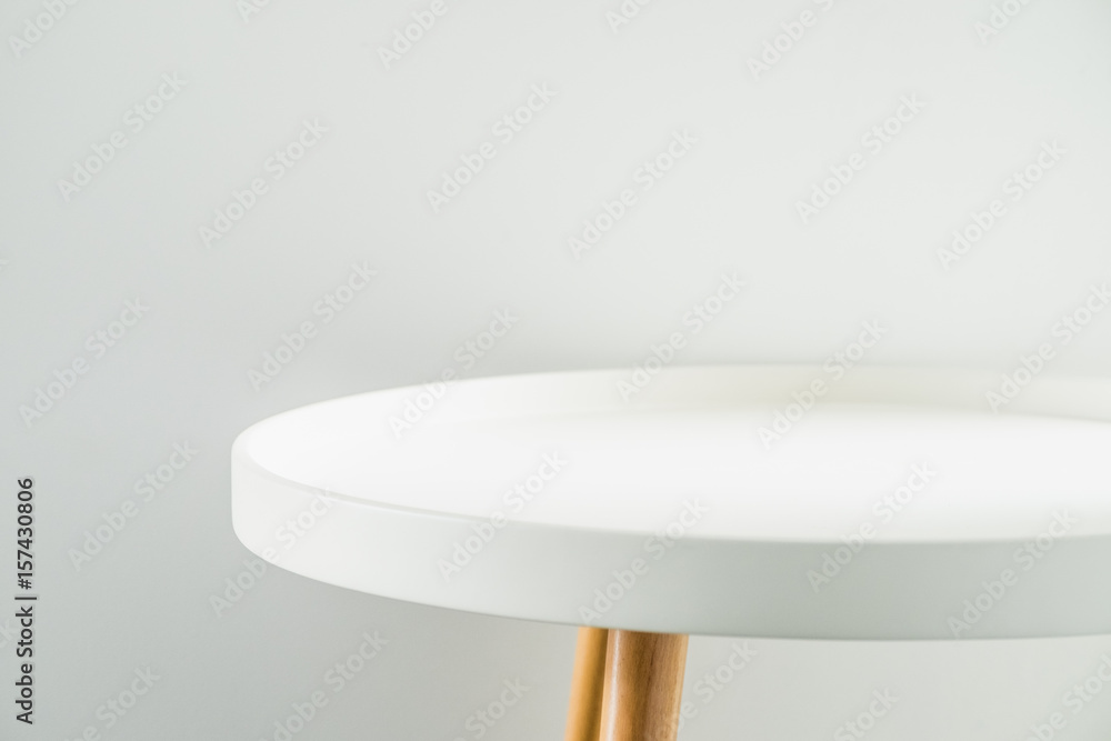 Poster empty modern round white table top at white house wall,mock up space for display or montage of produ