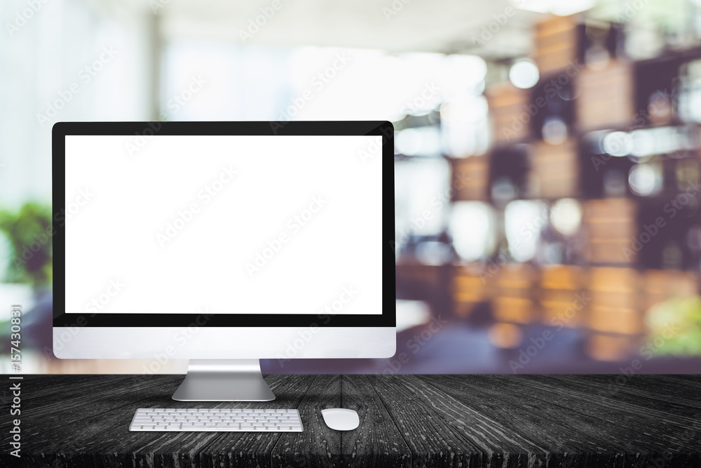 Poster blank screen desktop computer on black plank wooden table top with blur restaurant bokeh background,