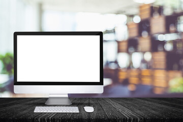 Blank screen desktop computer on black plank wooden table top with blur restaurant bokeh...