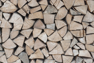 Fototapeta premium The firewood is stacked in a woodpile. Decorative wall of firewood