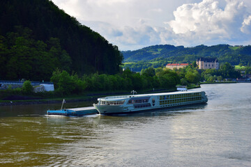 Obraz premium Motor ship sailing on the river Danube in Austria. Beautiful view from the bridge over the river.