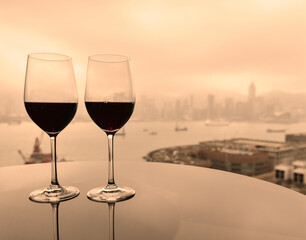 Two glasses of red wine with city view.
