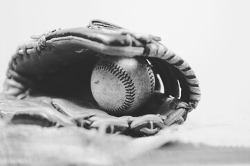 Black and white vintage baseball image of old leather mitt and antique ball in glove.  Great sports...