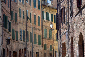Naklejka premium Cityscape - Siena, Tuscany, Italy. Background of typical city architecture, parts of buildings, Shutters, arches and windows.