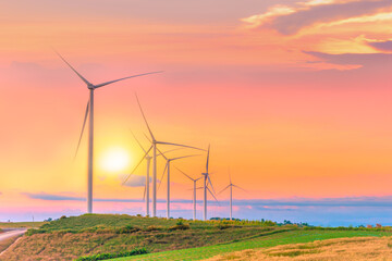 Windmills for electric power production on green field mountain in sunset time sky at Khao Kho,...