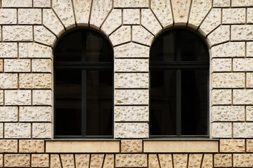 Facade of two arched windows of an old stone building