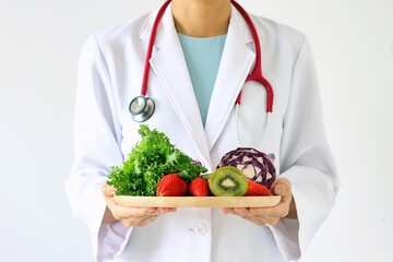 Doctor holding fresh fruit and vegetable, Healthy diet, Nutrition food as a prescription for good health. (Selective Focus) - obrazy, fototapety, plakaty