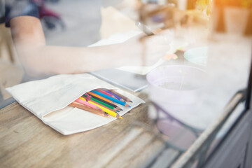 young woman sitting near window and writing