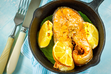Chum baked with lemon in a cast-iron frying pan.