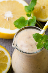 Banana and lemon smoothie, on the grey  background.