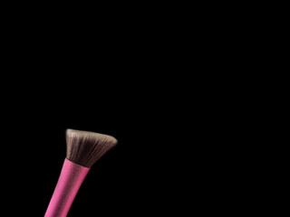 Cosmetic makeup brushes on  black background flash explosion splash powder shadow blush.