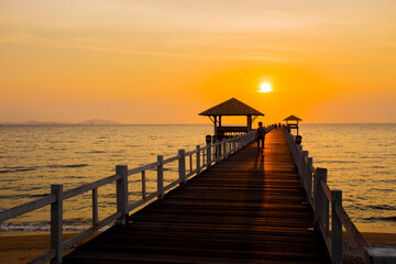 Fototapeta na wymiar The wooden bridge on sea at sunset, Thailand.