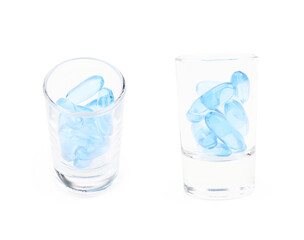 Shot glass full of softgel pills isolated