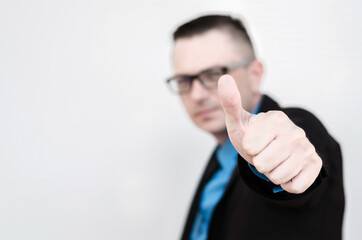 man shows ok sign with thumb in front of the wall with space for text