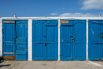 Row of blue doors against a blue sky