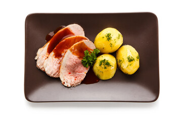 Roast pork chop steaks with potatoes on white background