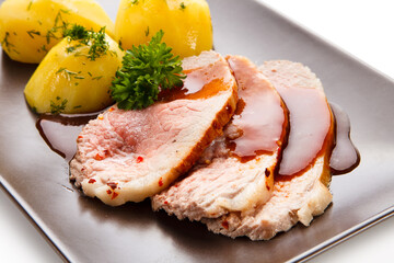 Roast pork chop steaks with potatoes on white background