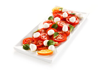 Caprese salad - mozzarella and tomatoes on white background