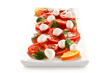 Caprese salad - mozzarella and tomatoes on white background