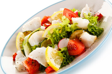 Salad with grilled fish fillet on white background