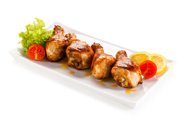 Roast chicken drumsticks on white background