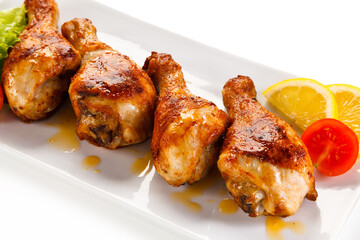 Roast chicken drumsticks on white background