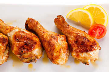Roast chicken drumsticks on white background