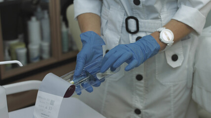 Beautician opens and prepares the syringe with hyaluronic acid for injections