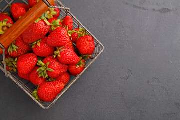 Ripe strawberry in a metal basket on a black background