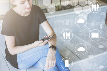 Close-up of a smartphone in female hands. In foreground are white virtual icons with clouds, people, digital gadgets.