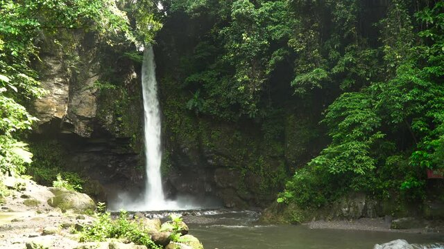 Beautiful waterfall in green forest in jungle. Waterfall in the mountains. Tropical rain forest with waterfall. Philippines, Camiguin. 4K video. Travel concept.