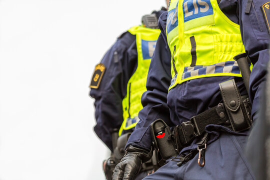 Two police officers, close up of upper body with vest and equipment belt.