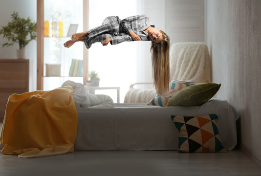 Sleep paralysis concept. Young woman levitating over bed