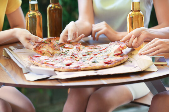 Female hands taking pizza from plate, closeup